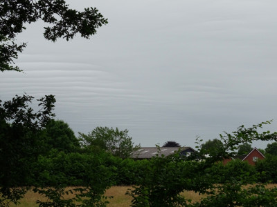 Atmosphärische Wellen in Wolkendecke sichtbar. Aufgenommen an einer Landstraße bei Bremervörde am 19.06.2022 um 12:49 MESZ.