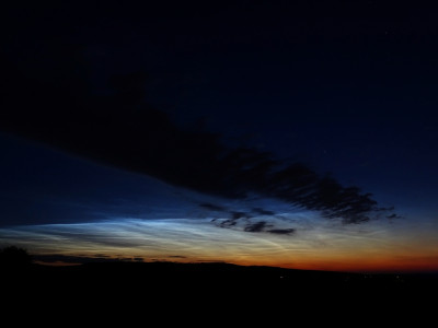 Abb. 1: 03:50 MESZ (Sonne 10.7° unter dem Horizont). Auffällig ist die scharfe, heller leuchtende Kante. Man erahnt bereits, dass darüber (eigentlich weiter südlich) weitere NLCs aus dem Erdschatten treten.