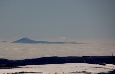 Milešovka/Milleschauer im Böhmischen Mittelgebirge , dahinter Riesengebirge mit Reifträger (links) und Schneekoppe (rechts)